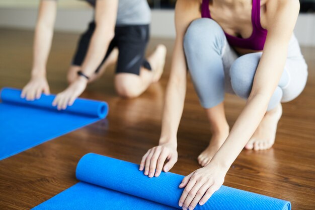 Rolling yoga mats after class