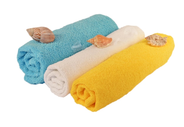 Rolls of blue white yellow towels with sea shells isolated