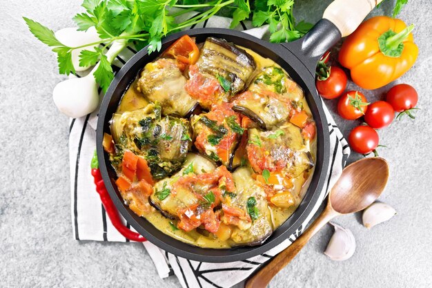 Rolls of eggplant with mincemeat in pan on stone top