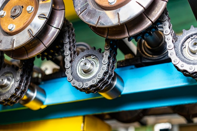 Rolls of an industrial machine for cutting metal with a chain transmission Conveyor line in a factory for processing sheet steel Closeup of production equipment