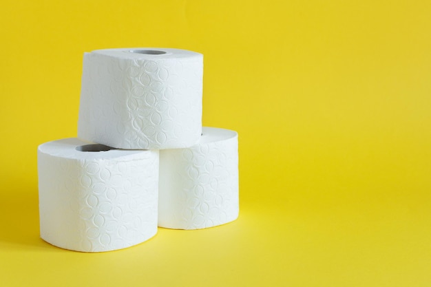 Rolls of toilet paper on yellow color background