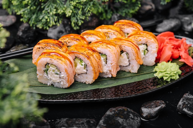 Rolls with fried salmon and cheese cucumber on plate