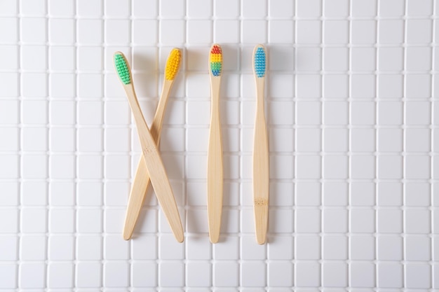 Roman numeral XII composed of toothbrushes on a white tiled background