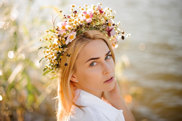 Romantic blond girl in a wreath of flowers