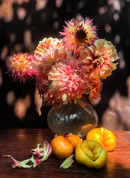 Romantic bouquet with dahlias and tomatoes in the glare of sunlight Summer bouquets of farm flowers outdoors in the garden Floristics  art of flowers arrangements