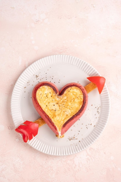 Romantic breakfast fried eggs in heart shaped sausages