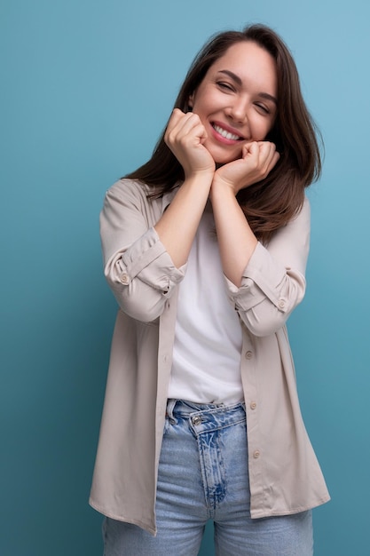 Romantic charming brunette year old female person dressed in a shirt and jeans on a studio