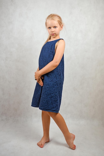 Romantic child in a blue dress in the studio portrait