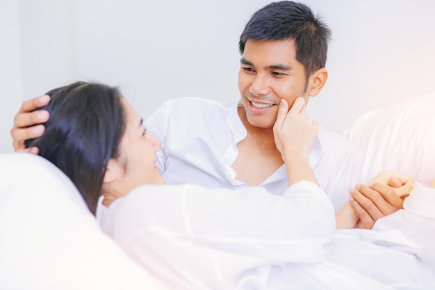 Romantic couple in bed holding hand together enjoy honeymoon morning at the bed