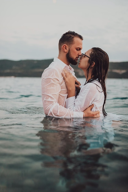 Romantic couple kissing in the sea at sunset High quality photo