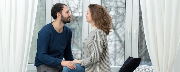 Romantic couple looking out of the window Quarantine at home