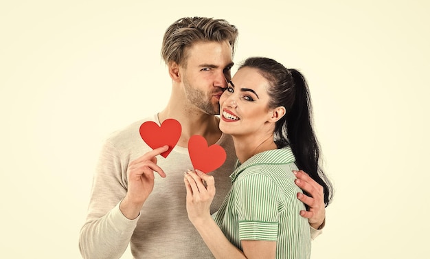 Romantic couple in love hug Handsome unshaven man and pretty girl in love Valentines day and love Romantic feelings concept Man and woman couple in love hold red heart card on white background