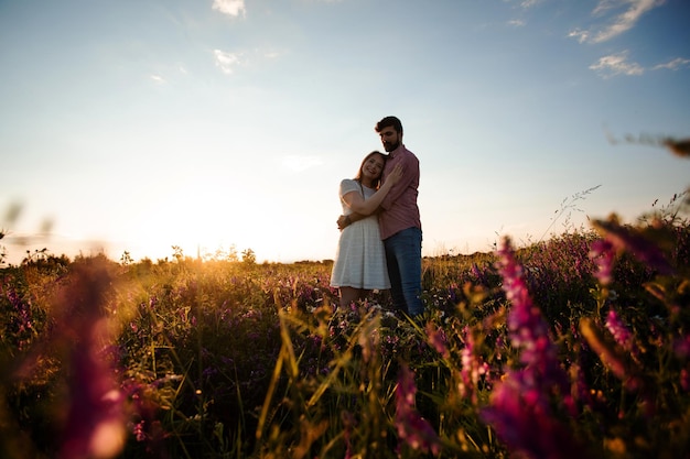 Romantic couple love moment in field among wild flowers