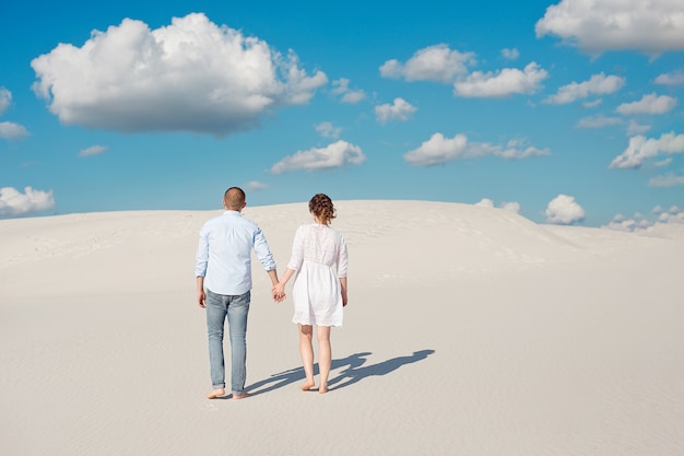 Romantic couple in love on the white sand in the desert.