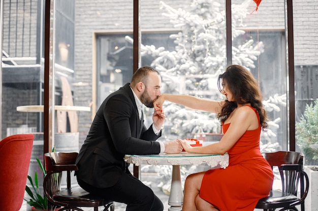 Romantic couple sitting in restaurant on a date near big window