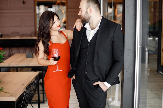 Romantic couple standing in restaurant on a date with glass of wine