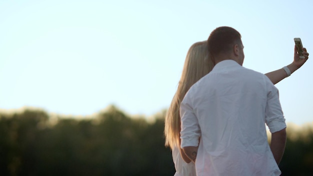 Romantic couple taking photo at sunset Sweet moment for lovely couple