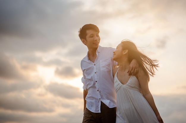 Romantic couple walking hugging each other while at beach at sunrise, plan life insurance at future concept. copy space for text. couple, love, beach, romantic, summer, lifestyle concept.