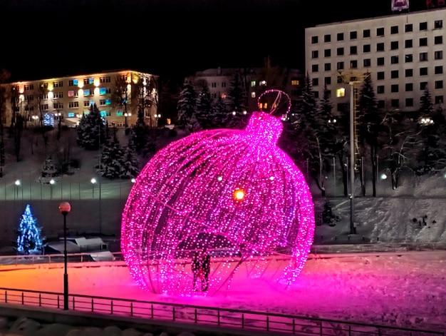 Romantic date in a winter city: a couple in a pastel art object "New Year's toy" in a park in a winter city, close-up