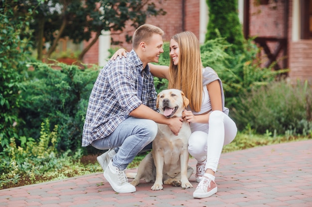 Romantic happy couple in love enjoying their time with labrador in nature.