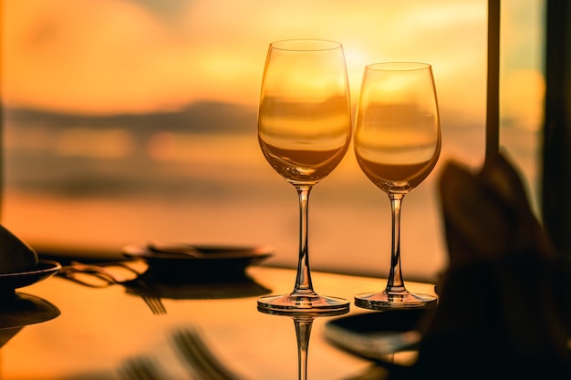 Romantic luxury dinner.Empty glasses and tropical sunset with sea background.Romantic evening with stunning sunset.