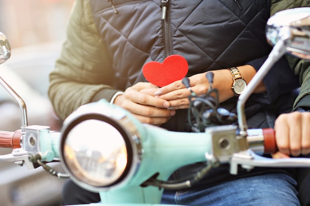 Romantic midsection of young couple riding scooter in autumn