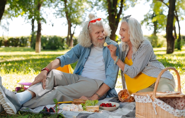 Romantic picnic. Pleasant elderly couple having a romantic picnic while being on a date