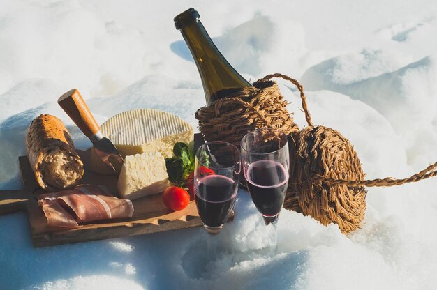 Photo romantic picnic with lambrusco cheese baguette and ham on snow food and drink outdoor in winter