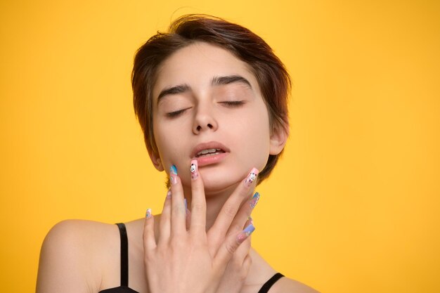 Romantic pretty girl with short haircut and extravagant nail art