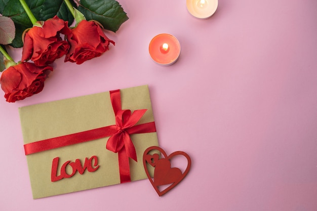 Romantic Saint Valentine pink background card with bouquet of beatiful red roses and Love gift envelope