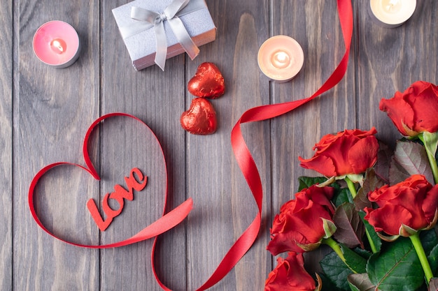 Romantic Saint Valentine wooden background card with bouquet of beatiful red roses and Love lettering