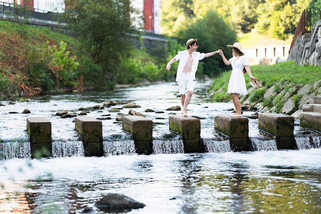 Romantic teenager couple crossing river