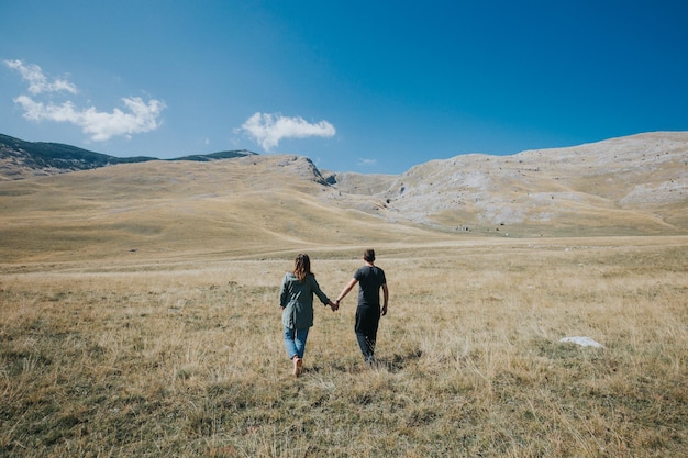 Romantic view of the Caucasian young couple kissing in the field