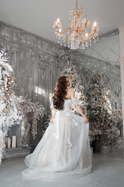 Romantic woman bride in a white wedding dress is waiting for the wedding ceremony at home Fabulous interior morning of the bride