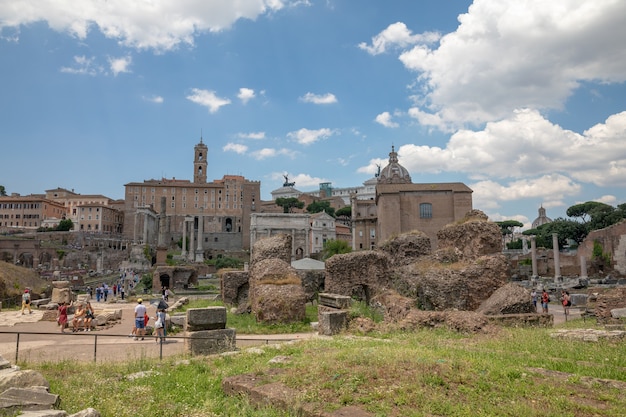 Rome, Italy - June 20, 2018: Panoramic view of Roman forum, also known by Forum Romanum or Foro Romano. It is a forum surrounded by ruins of ancient government buildings at center of city of Rome