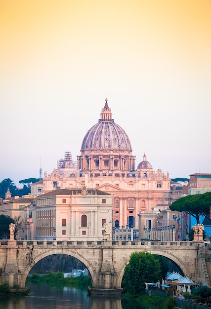 ROME, ITALY - JUNE 2020: sunset panorama on Tiber river bridge with Saint Peter Cathedral dome (Vatican City) in background - Rome, Italy