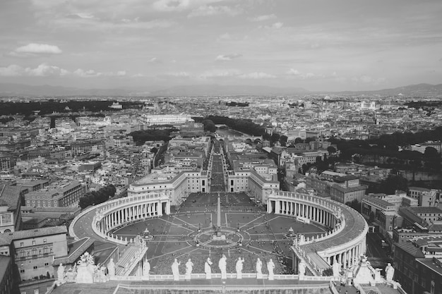 Rome, Italy - June 22, 2018: Panoramic view on the St. Peter's Square and city of Rome from Papal Basilica of St. Peter (St. Peter's Basilica). Summer day and people walk on square