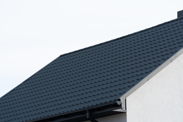 Roof of a new home Black metal tile roof Modern types of roofing materials