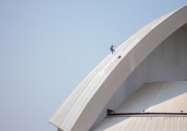 Roof repairman inspecting a damaged roof