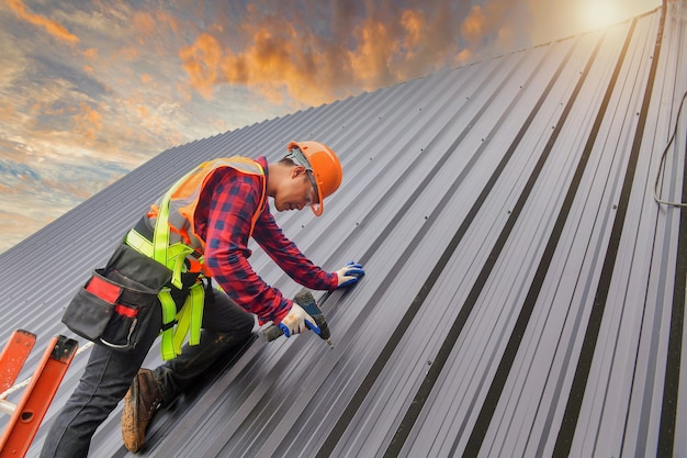 Roofer Construction worker install new roof,Roofing tools,Electric drill used on new roofs with Metal Sheet.