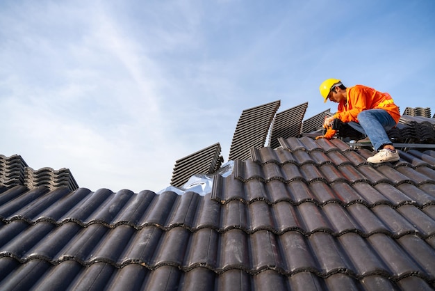 A roofer is installing a concrete roof on new roofs with Concrete Roof Tiles building under construction