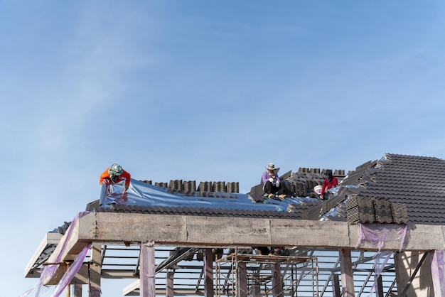 Roofers is installing insulating sheets on a concrete tile roof