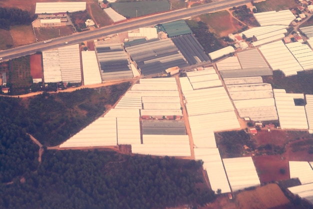 Roofs of greenhouses and roads the top view Toned