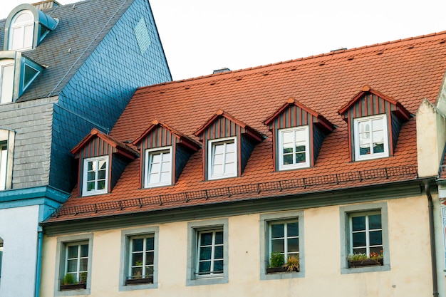 Roofs of old houses with roof windows and orange roof tiles in German city