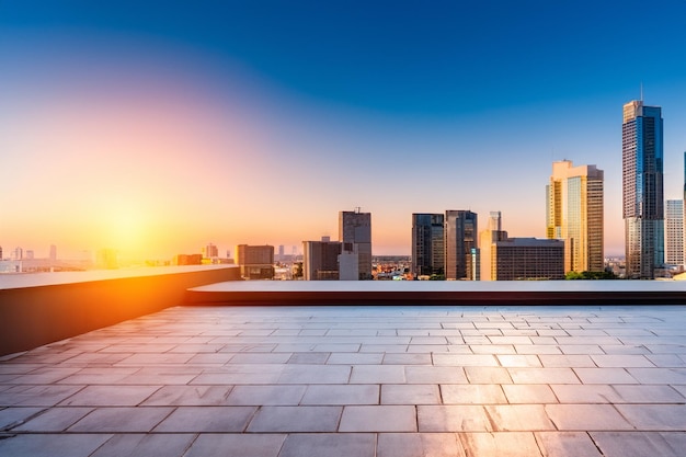 a rooftop with a view of the city skyline and the sun setting