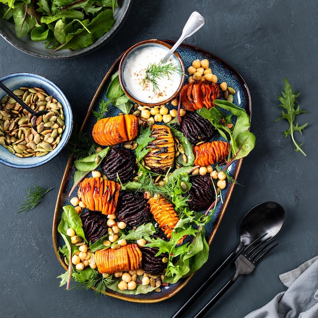 Root vegetables roast until soft in the center and crispy with chickpeas pumpkin seeds and fresh lettuce leaves Healthy fresh salad