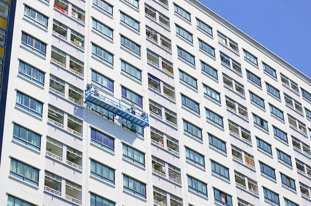 Rope access workers painting the facade of a high modern building