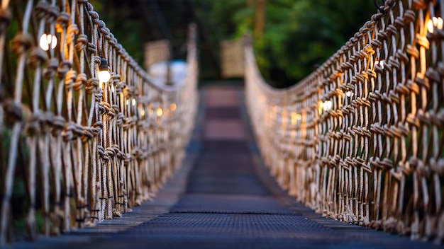 Rope bridge decorated with warming bulb light at twilight evening