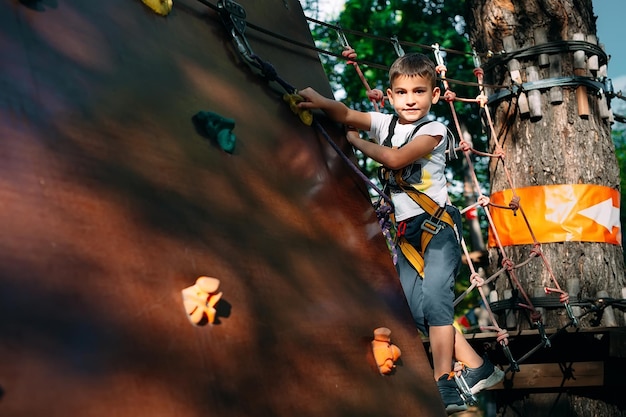 Rope Park. The kid passes the obstacle in the rope Park.