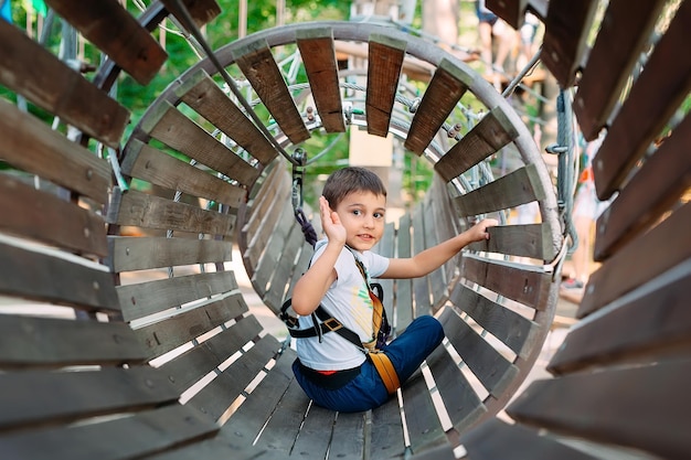 Rope Park. The kid passes the obstacle in the rope Park.